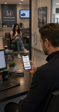 Dealership manager viewing an alert as a customer returns for automotive service